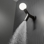 Soffione da soffitto Apollo in ottone con luce integrata di Antonio Lupi, su parete di piastrelle scure