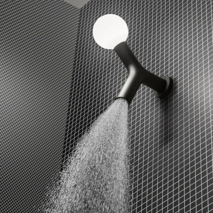 Soffione da soffitto Apollo in ottone con luce integrata di Antonio Lupi, su parete di piastrelle scure