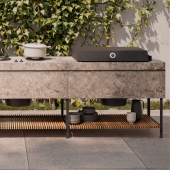 Cucina outdoor CUCINA BASE di Kettal completa di barbecue a gas e ripiano in legno iroko, installata in un giardino moderno