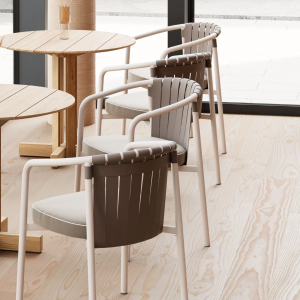 Sedia ARC di KETTAL dal design elegante con schienale a fasce intrecciate e struttura in alluminio bianco, ambientata in una sala da pranzo moderna con pavimento in legno chiaro
