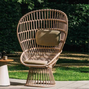 Poltrona CLUB Cala di KETTAL con struttura in corda beige e cuscino beige, su sfondo di giardino verde e luminoso