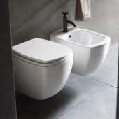 Design di lusso nel bagno moderno con sanitari sospesi 750 di Agape, in finitura bianca su piastrelle grigie e rubinetto nero