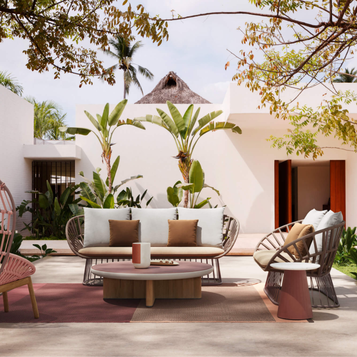 Tavolino Basso Cala di Kettal in un elegante terrazzo urbano - arredo di lusso con divani e poltrone coordinate, illuminazione soffusa e vista sui grattacieli."